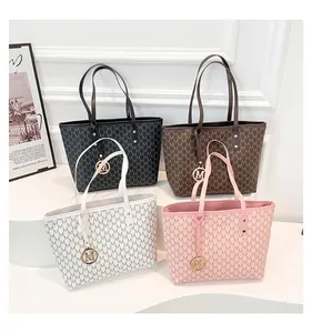 Detail shot of four monogram tote bags in black, brown, white and pink with M-letter charms
