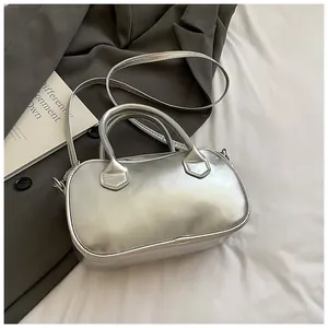Dettaglio macro della borsa bowling argento con trama in pelle e manici eleganti