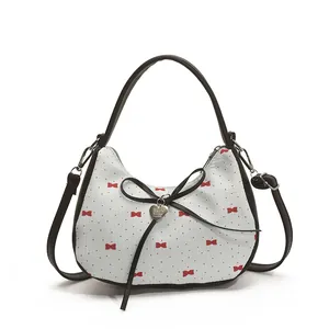 Sac sous le bras blanc à imprimé nœud rouge, poignée noire et pendentif cœur