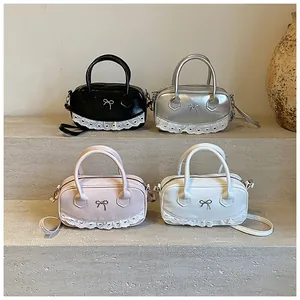 Dettaglio di borse Boston in nero, argento, rosa e beige con fiocchi e pizzo