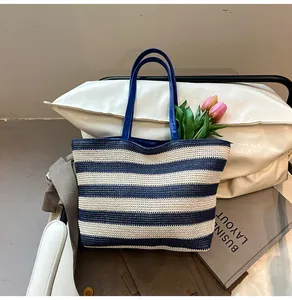 Detailed view of woven striped tote bag with leather handles and interior tulips