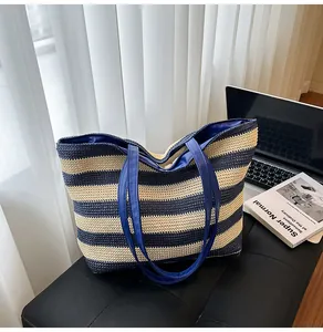 Detail of navy blue and beige striped woven tote bag with smooth synthetic leather handles