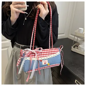 Detail der blauen Denim- und Karo-Tasche mit Spitzenbesatz und Kirsch-Stickerei