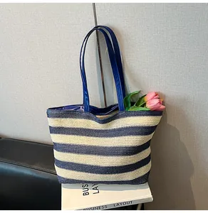 Close-up of navy blue striped woven tote bag featuring high-quality leather handles