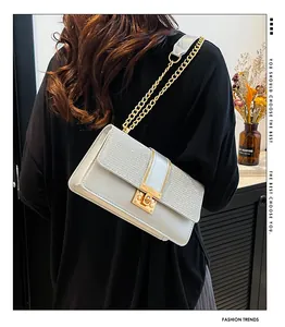 Detail of silver sequined crossbody bag with gold buckle on shoulder in home setting