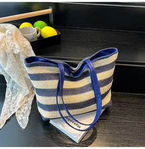 Detailed view of blue and white striped woven tote bag on a rustic wood background