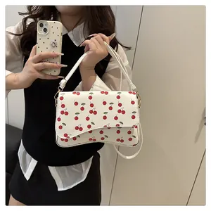 Détail du sac blanc avec imprimé cerise et rabat aux bordures festonnées