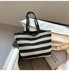 Close-up of woven black and white striped tote bag with high-quality leather handles