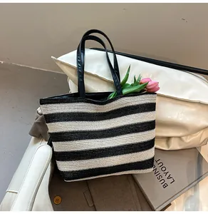 Detail of black and white striped woven tote bag with premium leather shoulder straps