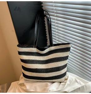 Detail of black and white striped woven tote bag with leather handles and fabric lining