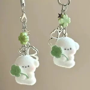 Cute white flocked puppy keychain with green four-leaf clover and silver heart pendant