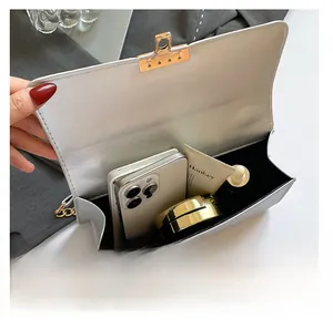 Internal view of a white sequined crossbody bag showing space for phone and makeup