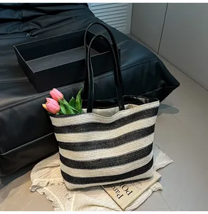 Detail of the woven texture and black leather handles on a striped tote bag