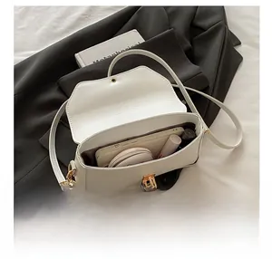 Détail intérieur du sac à bandoulière blanc montrant la capacité et le fermoir doré élégant
