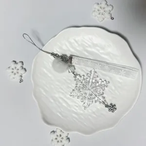 Winter snowflake charm with white plush ball, ribbon, and transparent crystal pendant