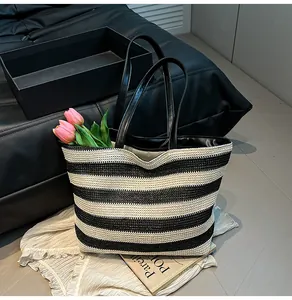 Close-up of black and white striped woven tote bag with premium leather handles