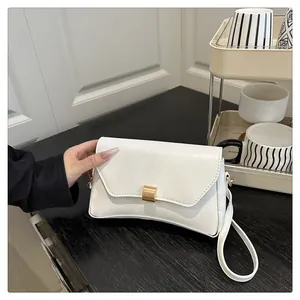 Détail d'un sac à bandoulière blanc minimaliste avec une boucle dorée rectangulaire