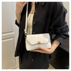 Vue style de vie du petit sac carré blanc avec boucle dorée et bandoulière fine
