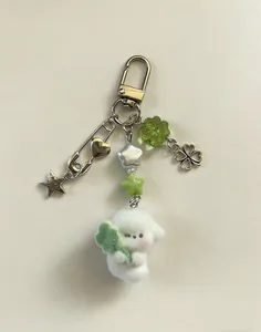 Macro detail van pluche puppy sleutelhanger met klavertje vier en metalen bedeltjes