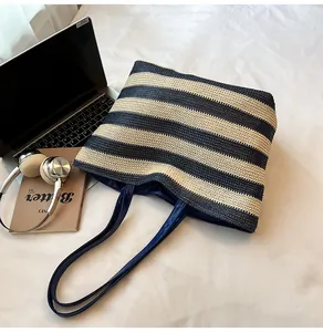 Macro shot of striped woven tote bag with navy blue handles and fabric lining detail