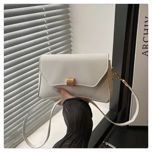Gros plan du sac à bandoulière crème avec une boucle rectangulaire en or brossé