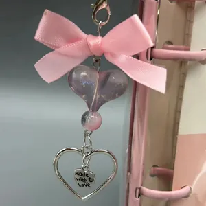 Sleutelhanger met roze strik en paarse hartvormige hanger met Made with Love gravure