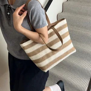 Women's woven striped tote bag with brown leather handles in a stylish summer look