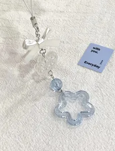Détail d'un charme fait main avec étoile bleue et nœud blanc pour sacs
