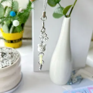 Gros plan d'un pendentif ours mignon avec perles dépolies et petit cœur en métal argenté