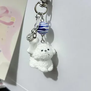 Porte-clés chien en peluche blanc avec perles rayées et breloque en forme d'os mignon