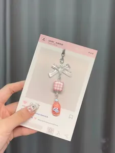Nahaufnahme eines rosa Perlen-Schlüsselanhängers mit Mini-Saftflasche und transparenter Schleife