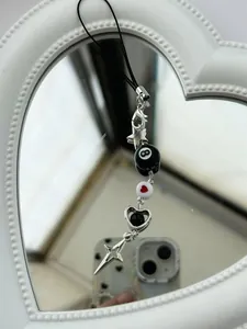 Detailed view of Y2K beaded phone charm with black number 8 pool ball and silver heart charms
