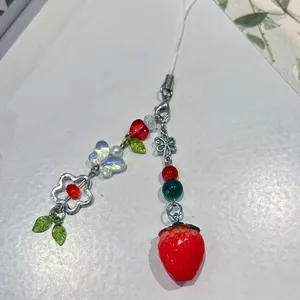 Close-up of handmade beaded keychain featuring a red strawberry and butterfly charm