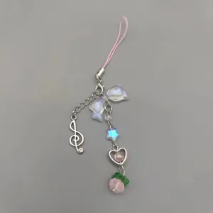 Detailed view of pink beaded phone charm with bow star and heart shaped pendants