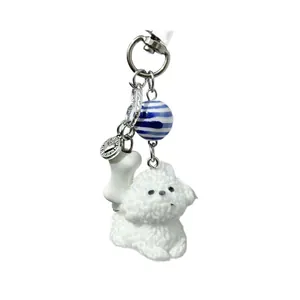 Porte-clés chien en peluche blanche avec perles bleues et pendentif os pour sac