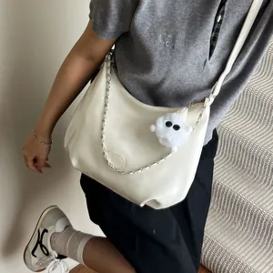 Chic beige hobo tote bag with adjustable strap and decorative plush charm for women