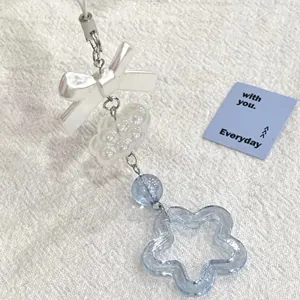Bijou de téléphone fait main en perles bleues et blanches avec étoile et nœud papillon