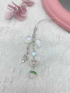 Close-up of pink beaded phone charm with butterfly knot, heart frame and peach bead