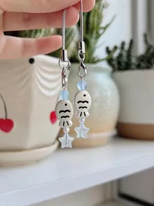Close-up of cute fish and star charms with blue beads for phone or bag decor