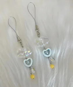 Dettaglio dei ciondoli con perline pastello, nuvole iridescenti e cuori blu