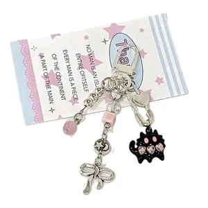 Cute pink and black beaded cat keychain with metal charms and bow on a star card