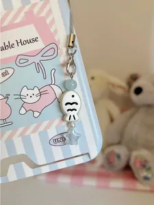Detailed view of a cute blue star and ceramic fish phone charm with silver clasp
