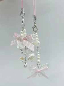 Detail of pink ribbon bow phone charms with pearls and translucent butterfly pendants