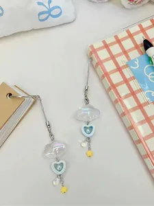 Dettaglio di ciondoli per cellulare con nuvole, cuori di perla e piccoli pendenti stella