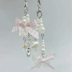 Pink and white bow phone charms with pearls and butterfly pendants in coquette style