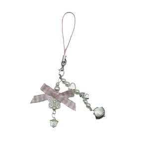Pink bow phone charm with silver butterfly, pearls, and heart charms on a white background