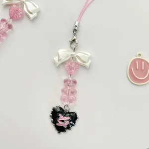 Pink heart bear beaded phone strap with white bow and heart pendants on white background