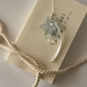 Exquisite snowflake crystal charm with white ribbon on a vintage book background
