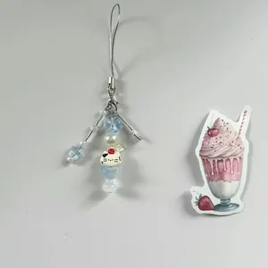 Sweet beaded phone charm with cat bead, star, and pearl details on grey background