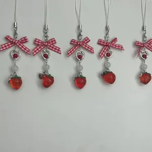 Cute strawberry bow phone charm with heart pendants and red checkered ribbons